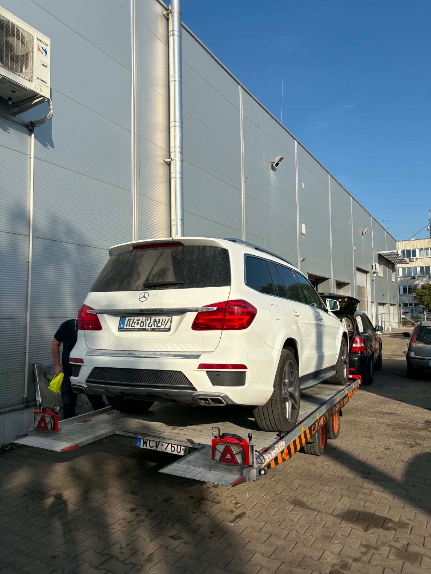 Fehér Mercedes GL felmálházva a trélerre